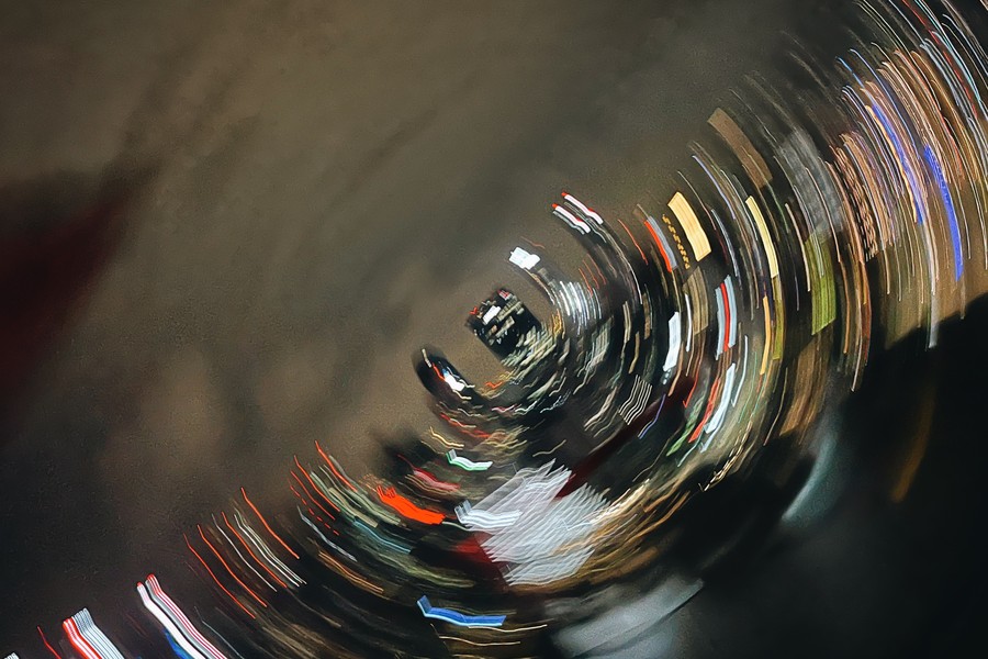 A spiralling tunnel of light trails curving toward a distant vanishing point