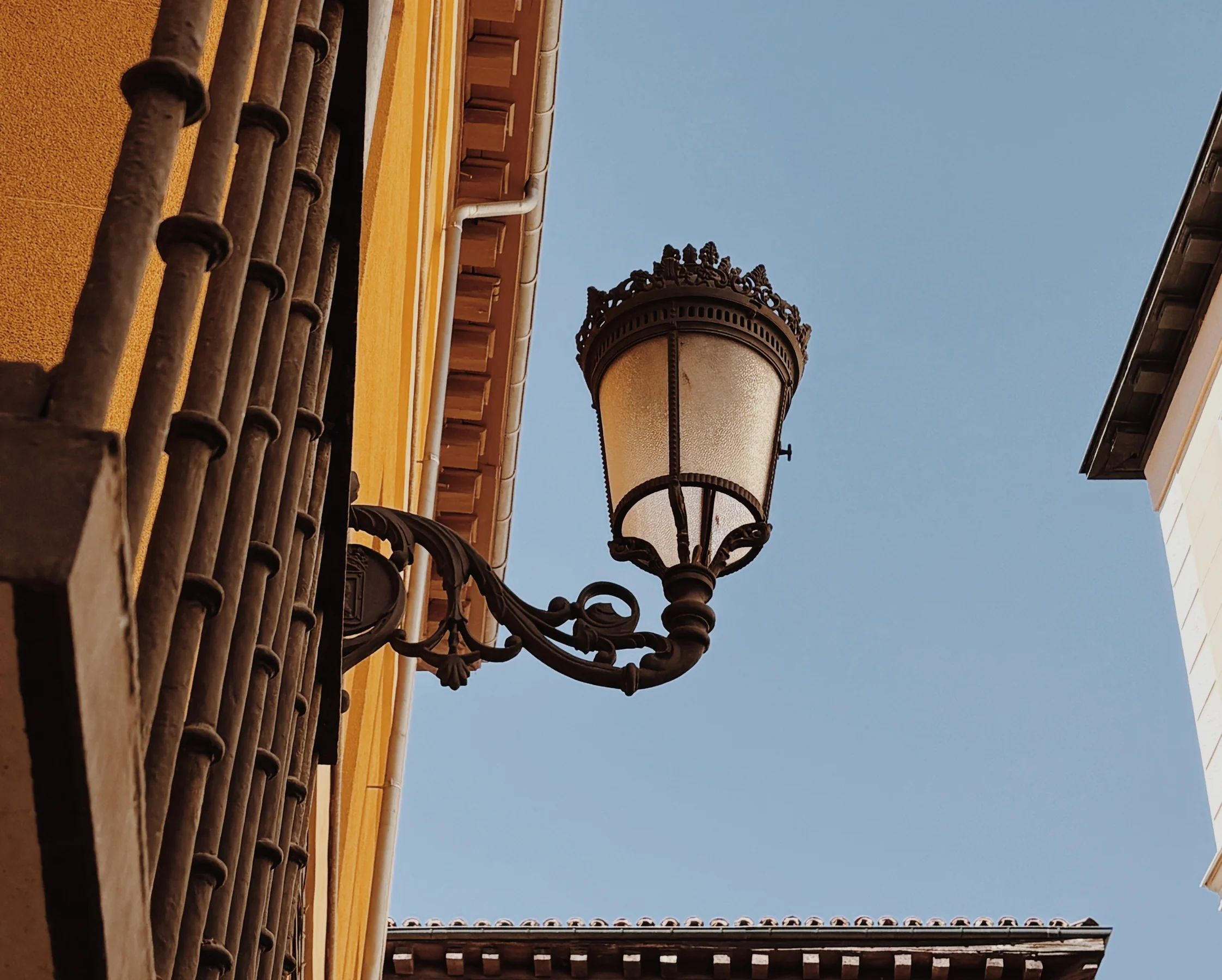 A single lamp in warm silhouette against a blue sky, Madrid